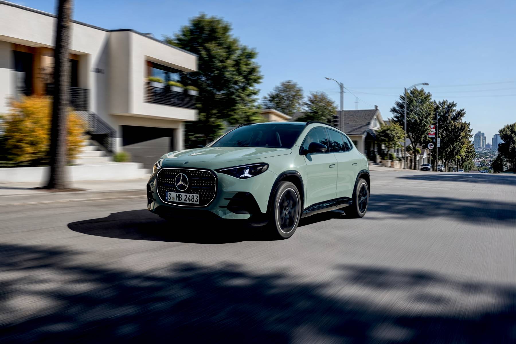 Nouveau Mercedes-Benz GLA électrique de couleur vert clair vu de trois quarts avant en circulation dans une rue résidentielle