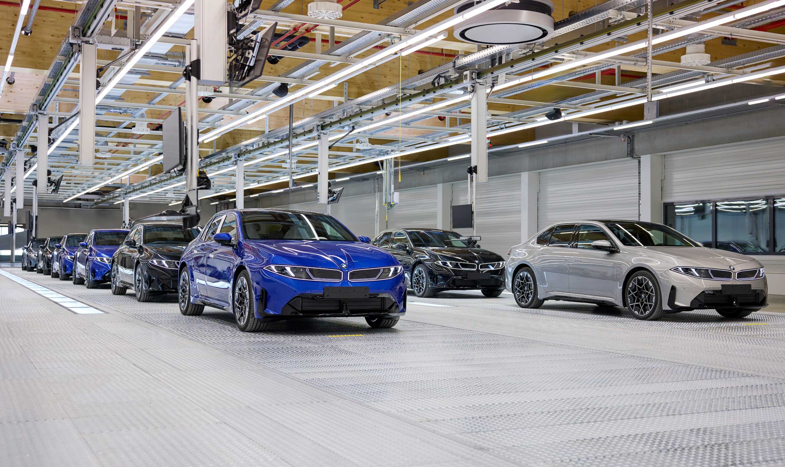 Alignement de BMW i3 bleues, noires et grises en fin de ligne d'assemblage dans l'usine BMW de Munich