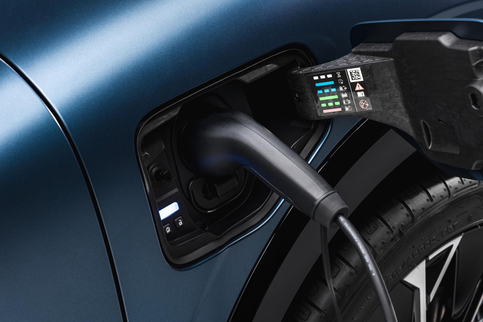 Connecteur de recharge inséré dans la trappe de charge d'une voiture électrique