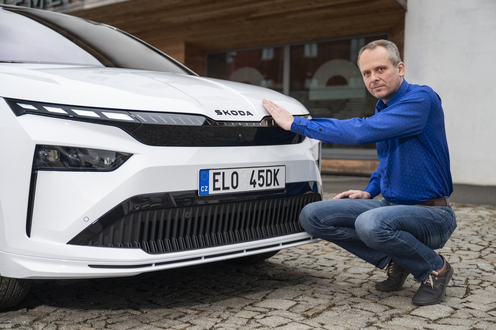 Ingénieur aérodynamicien de Škoda examinant la face avant d'une Škoda Enyaq blanche