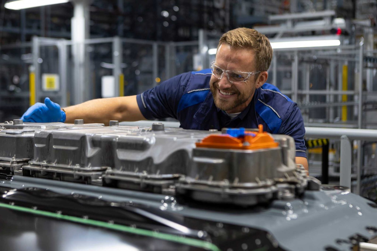 Technicien BMW en gants bleus vérifiant le module de commande installé sur un pack de batterie haute tension Gen6