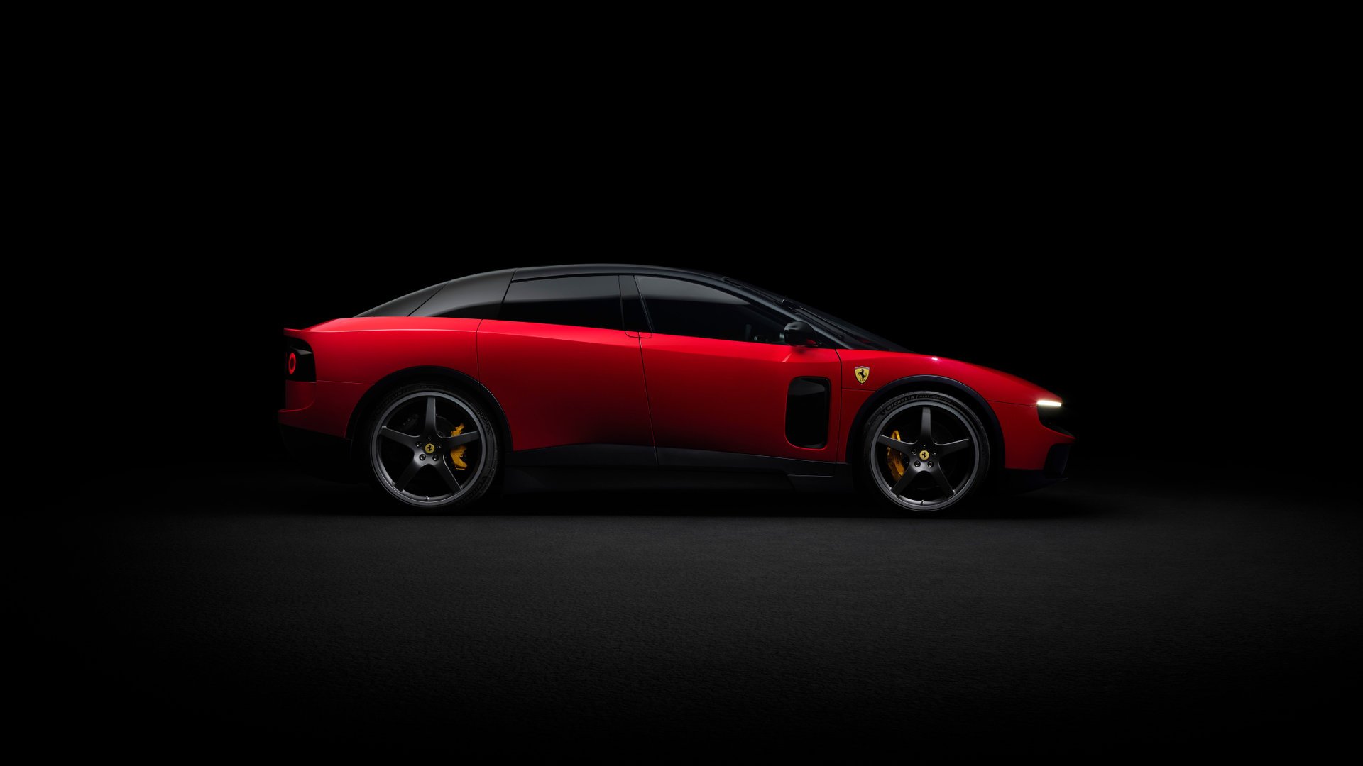 Ferrari Luce rouge vue de profil sur fond sombre de studio, silhouette basse à quatre portes