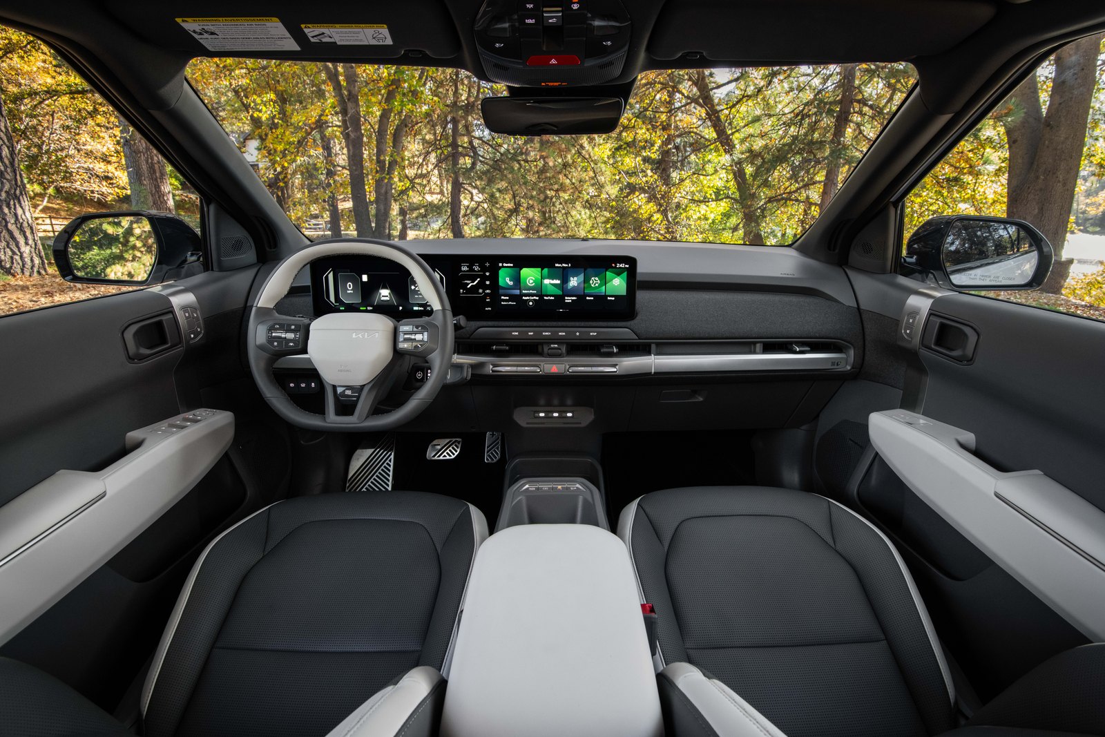 Planche de bord du Kia EV3 avec double écran panoramique et console centrale claire