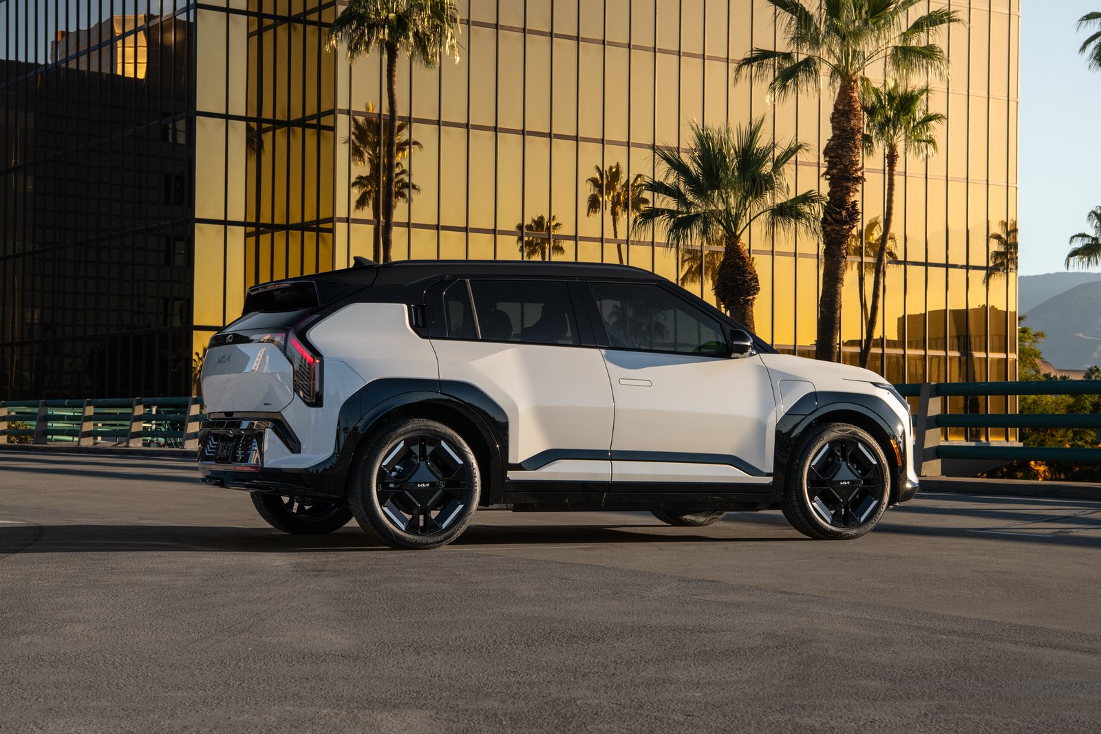 Kia EV3 blanc vu de trois quarts arrière, hayon et bloc optique vertical visibles