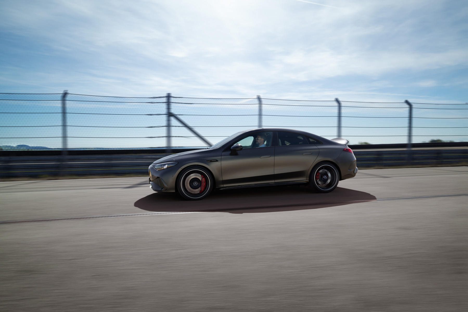 Mercedes-AMG CLA 45 4MATIC+ électrique grise de profil sur circuit, aileron arrière actif déployé