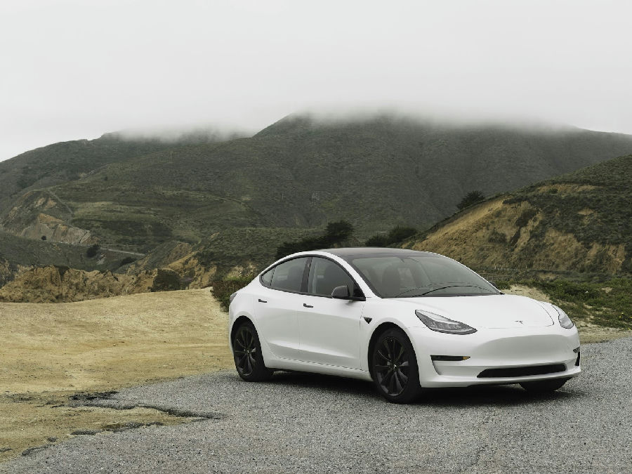 Tesla Model 3 2024 vue de profil sur route électrique
