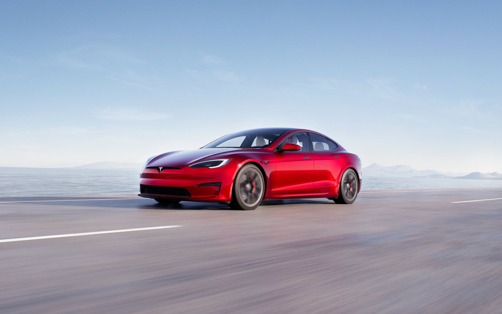 Berline Tesla Model S vue de trois quarts avant sur une route dégagée
